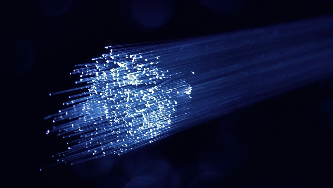 Faisceau de fibres optiques transportant un signal lumineux bleu — illustration de la mesure par photométrie